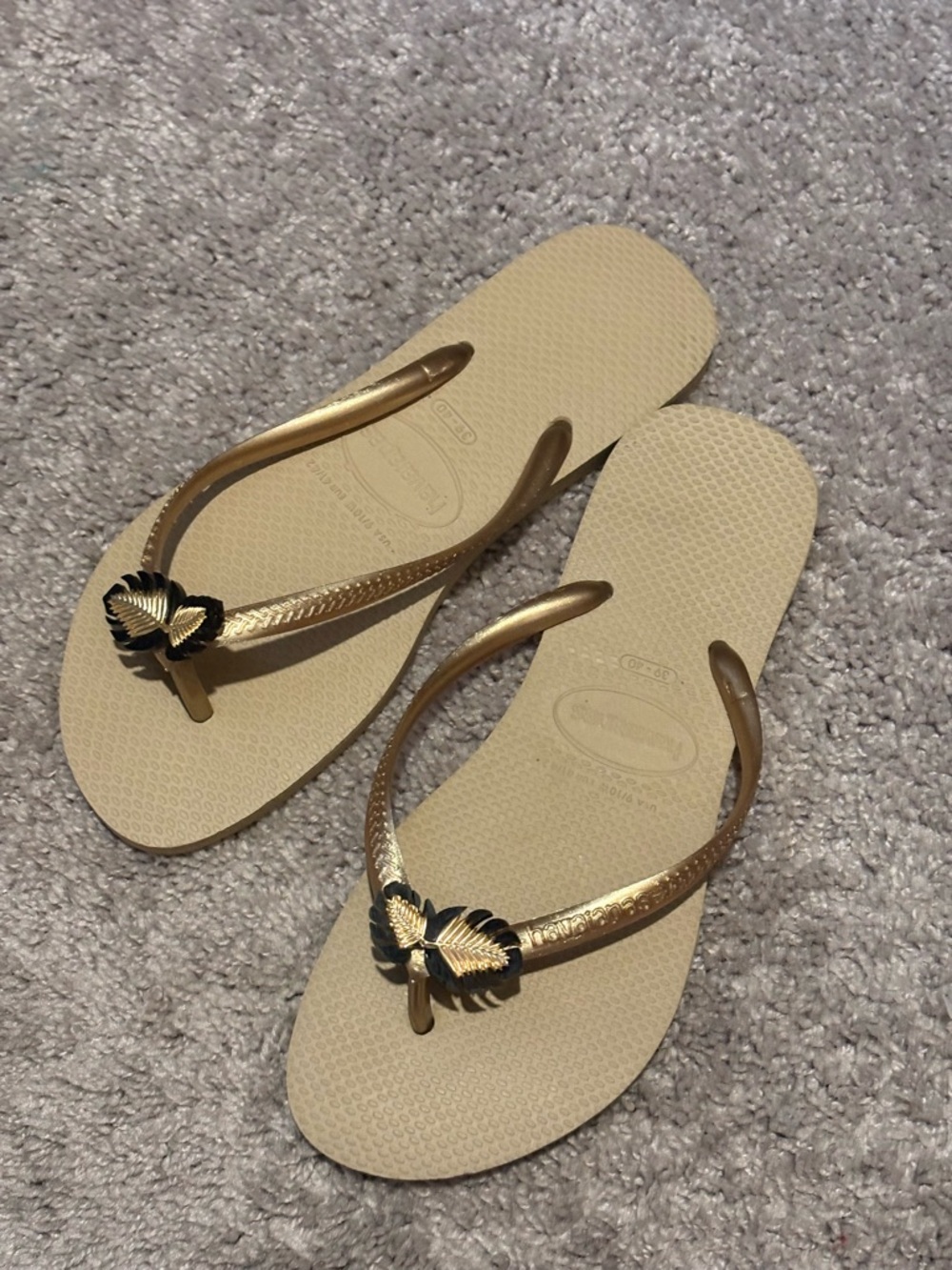 Havaianas Slim Sandals in Cream with Gold Straps and Black Leaf Accents